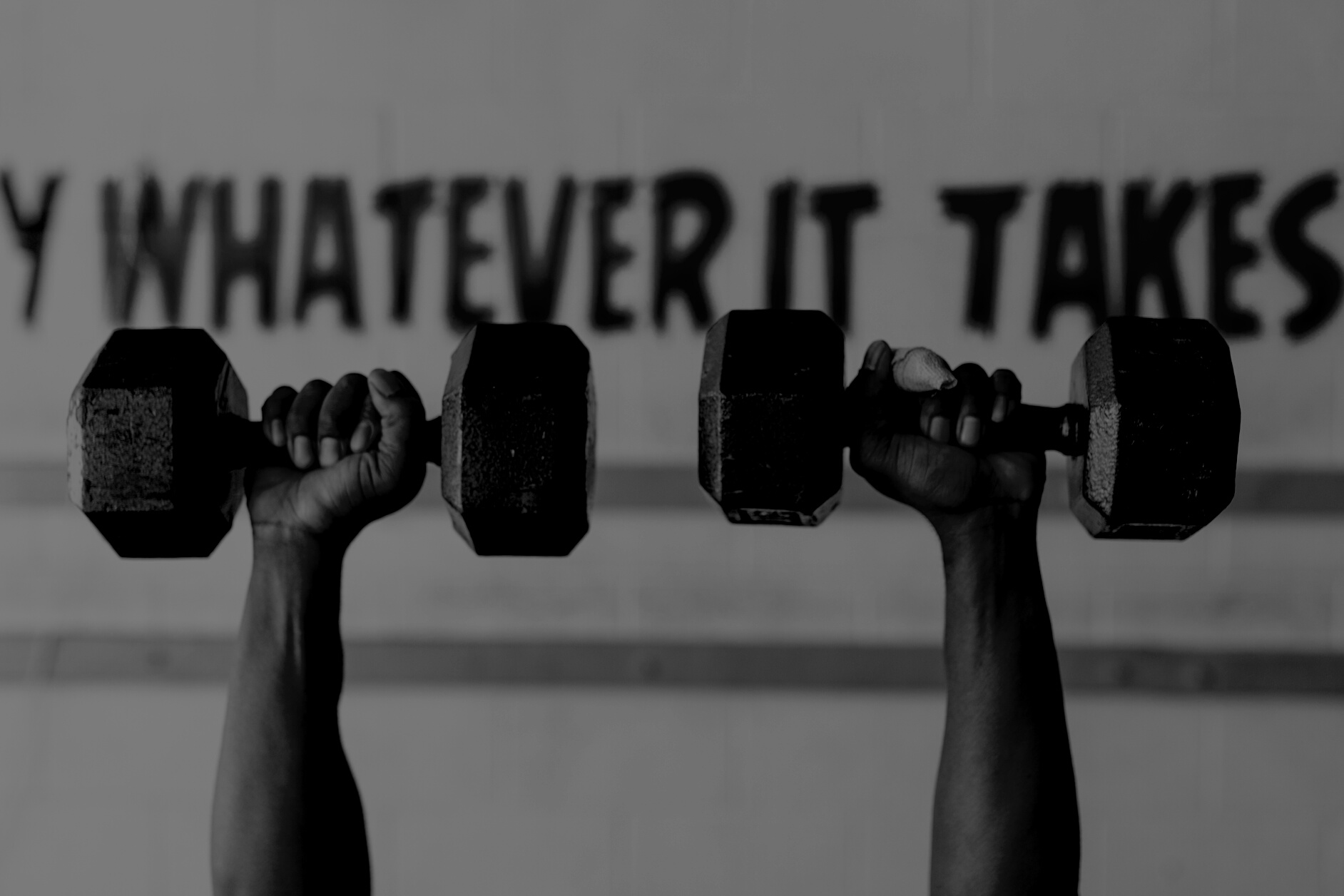 Shallow Focus Photo of Person Lifting Two Heavy Dumbbells